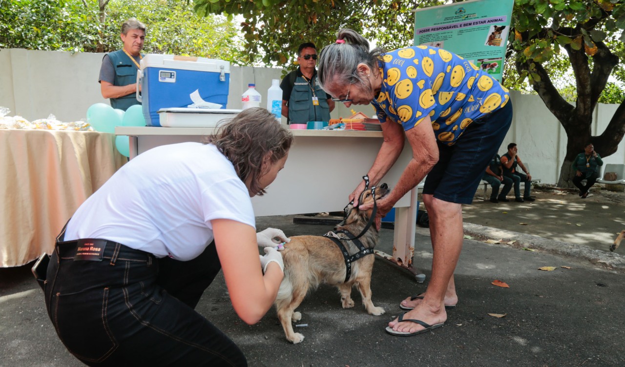 agente de saúde vacinando um cachorro